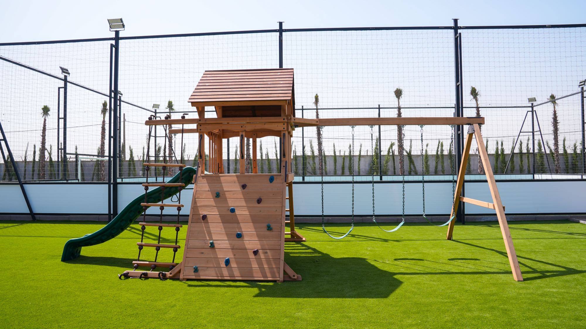Aire de jeux pour enfants installée sur gazon synthétique